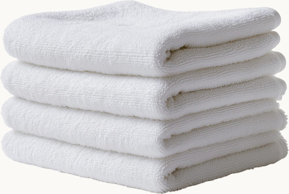 A neatly folded stack of white bath towels